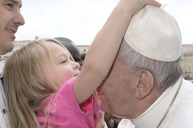 На фото девочка снимает с Папы Римского головной убор