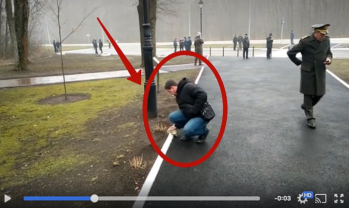 В Харькове мужчина натирает тряпкой белый бордюр вдоль дорожки, по которой пройдут польский и украинский президенты. ВИДЕО