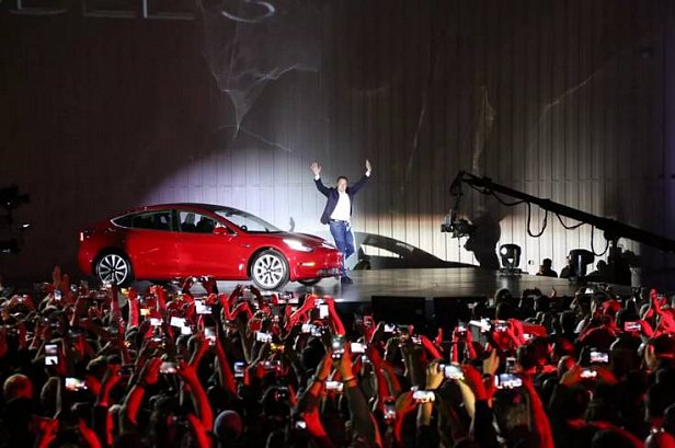 На фото Илон Маск на фоне автомобиля Tesla Model 3